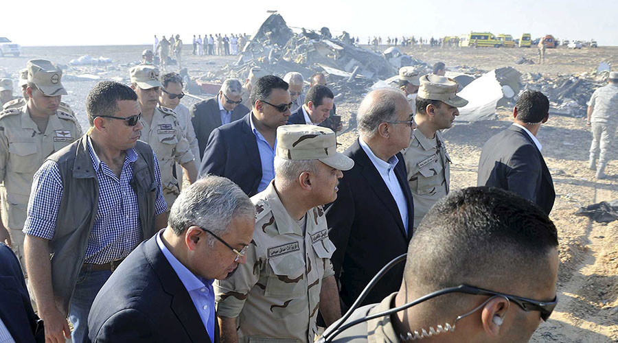 Egypt's Prime Minister Sherif Ismail (C) and Egypt's Defense Minister Sedki Sobhi (2nd L) walk at the site where a Russian airliner crashed in central Sinai near El Arish city